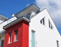 Neubau mit roter Holzfassade und weißem Putzbau, Spenglerarbeiten an den Detailanschlüssen